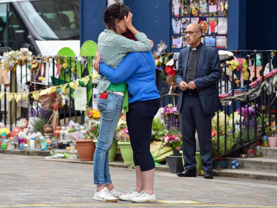  Two friends hug during the Grenfell Tower anniversary event today