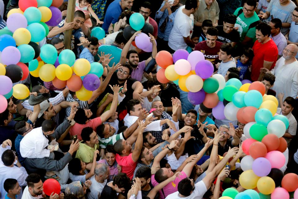  Muslims try to catch balloons distributed for free after Eid al-Fitr prayers in Cairo, Egypt, in 2018