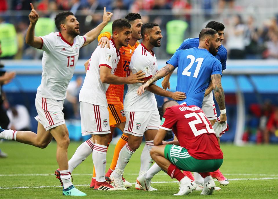  Iran celebrate as Aziz Bouhaddouz hangs his head following an own-goal