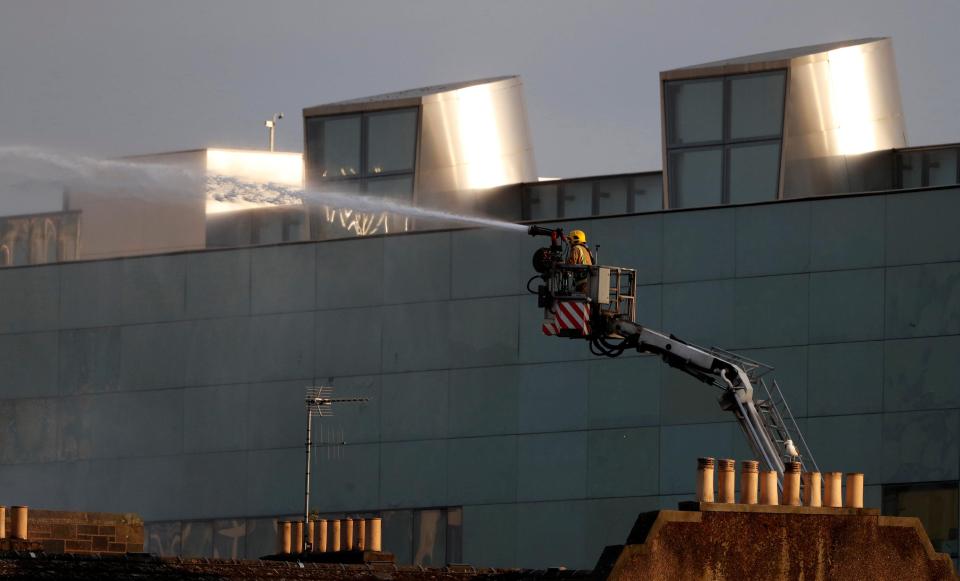  Firefighters were this morning picture dampening the smouldering remains of the building