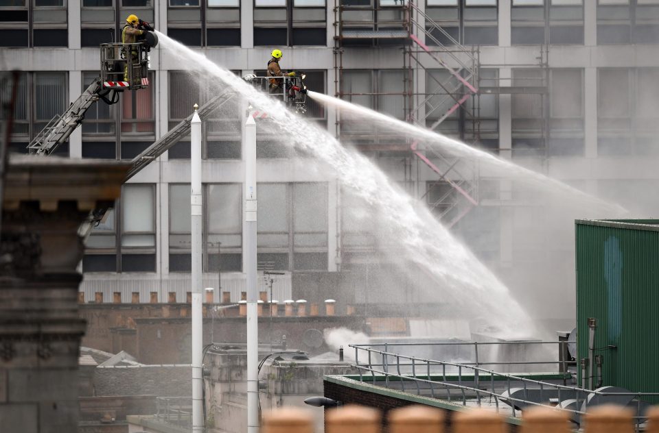  Firefighters are working to damp down the smouldering building in Glasgow