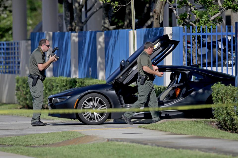  Investigators surround a vehicle after rapper XXXTentacion was shot on Monday