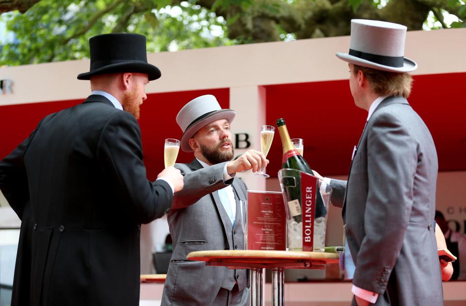  Friends in top hats toast to a good day at the races as they enjoy champagne at Royal Ascot