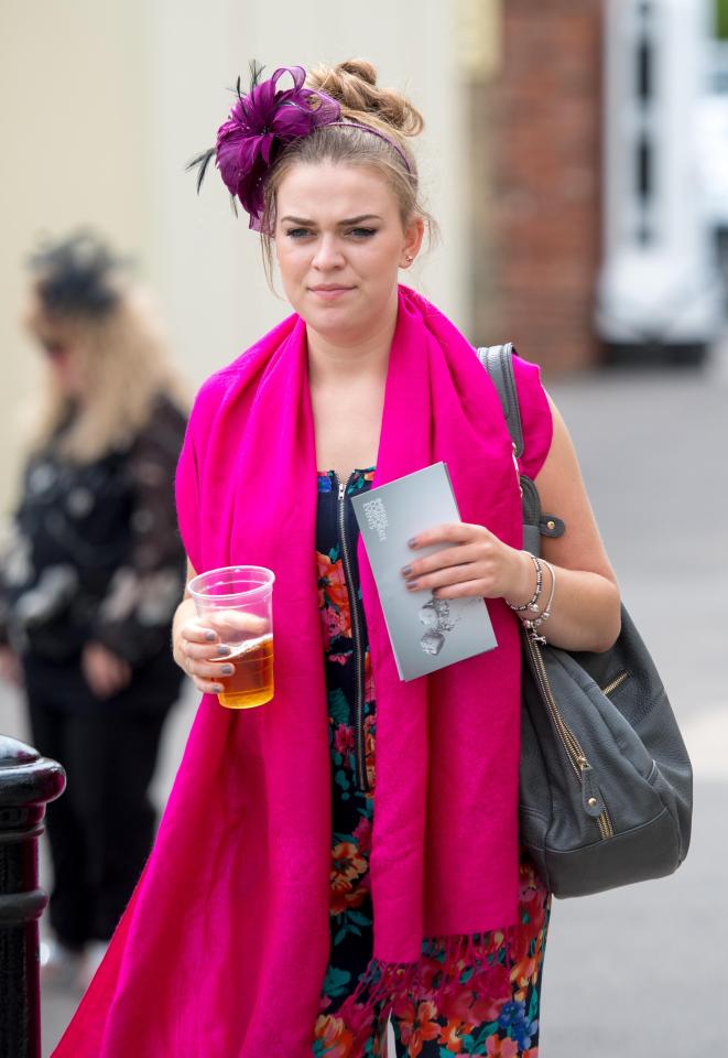  A woman clutches her beer as she makes her way across Royal Ascot today