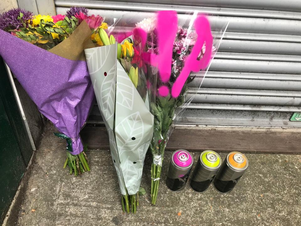  Floral tributes sit alongside three cans of spray paint at Loughborough Junction station