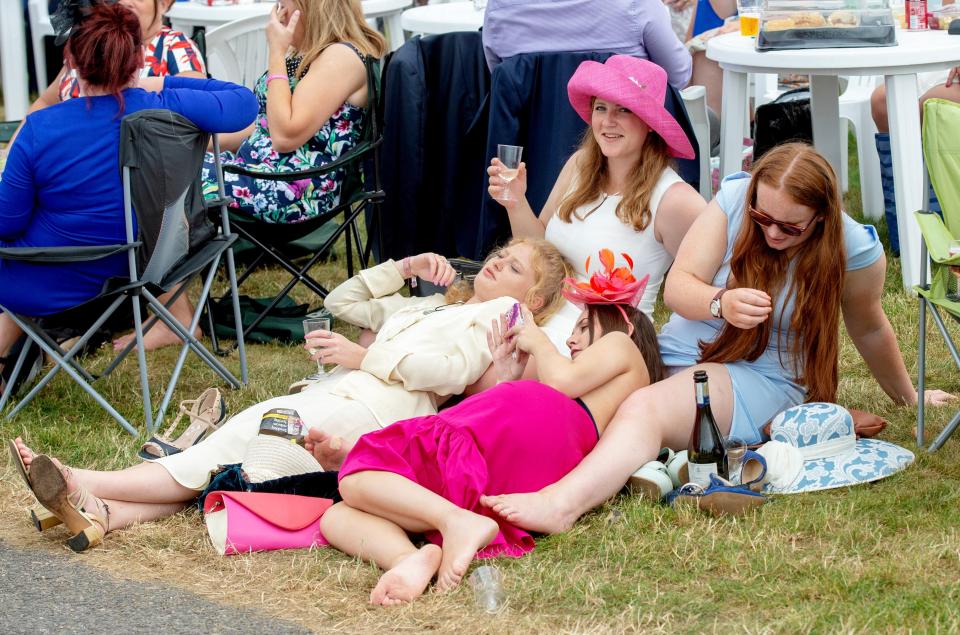  Racegoers soak up the atmosphere with a glass of fizz in hand