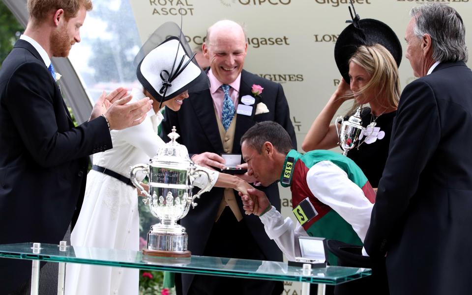  Frankie Dettori leans down and kisses Meghan Markle's hand after winning the 2018 St James's Palace Stakes at Ascot