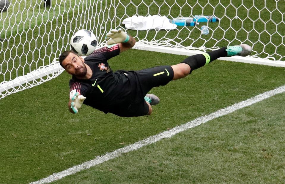  Portugal goalkeeper Rui Patricio dives full-length to save and keep Portugal in the lead against Morocco