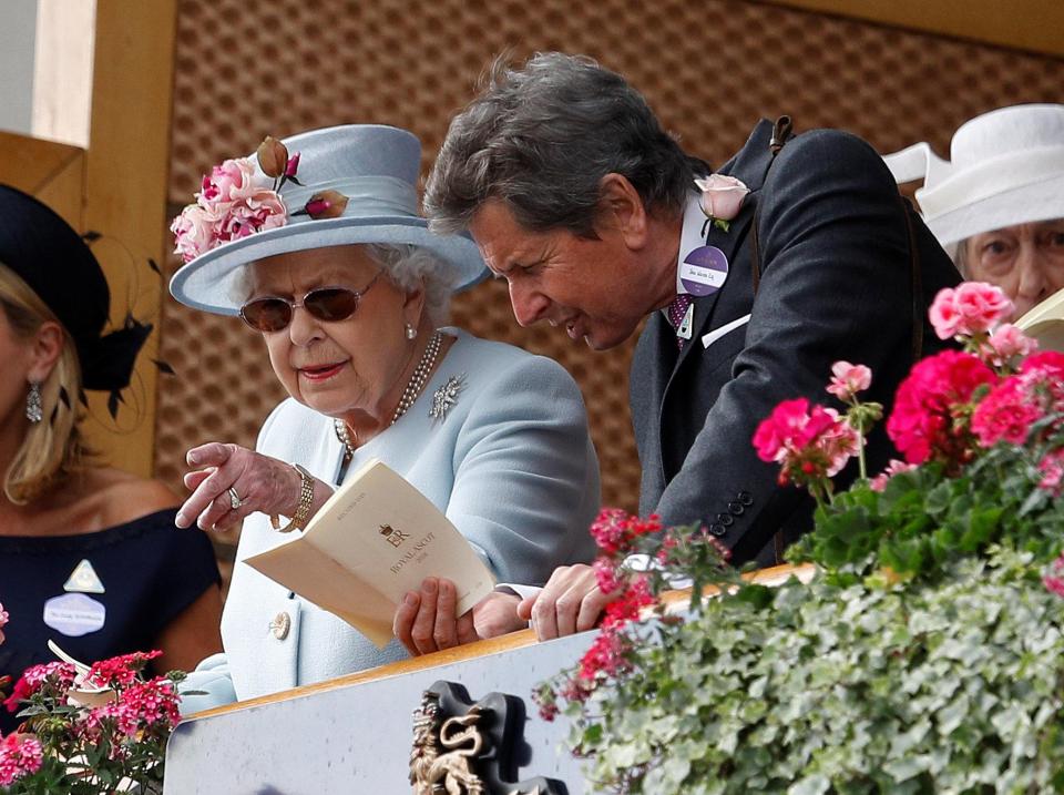  Her Majesty points at something below as her companion studies the form