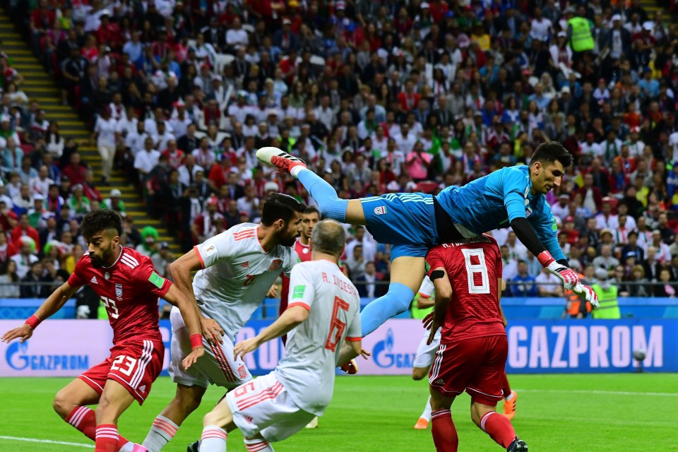 Iran’s goalkeeper Alireza Beiranvand flies through a crowd to make a punch