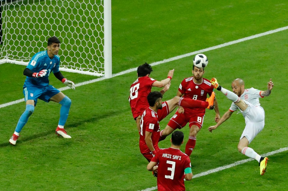 David Silva tries to shoot while surrounded by Iranian defenders