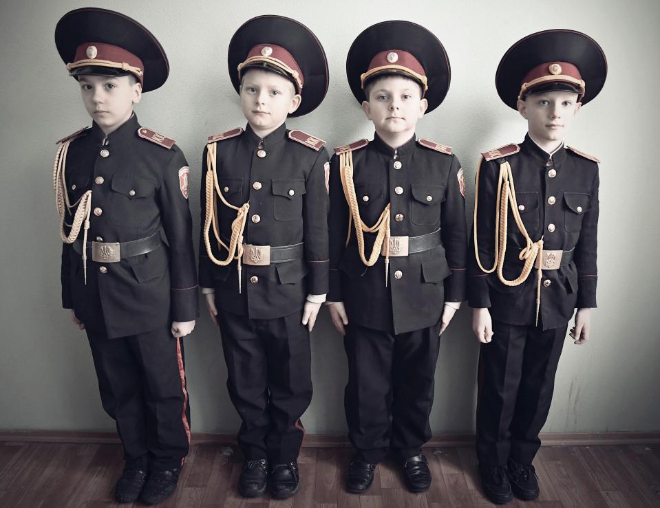  Four young boys in Ukraine are dressed in traditional military uniforms