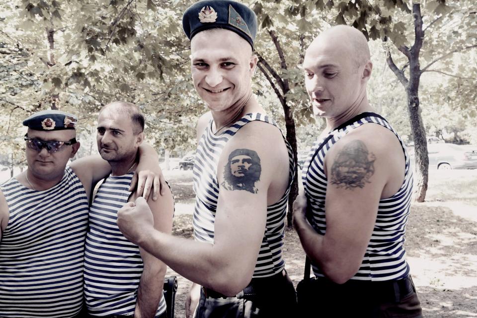  Two young soldiers show their muscles and tattoos during a celebration day