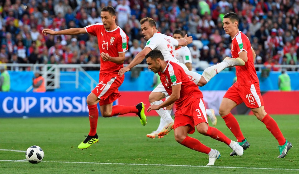 Xherdan Shaqiri fights for the ball with Serbia’s Nemanja Matic and Dusko Tosic