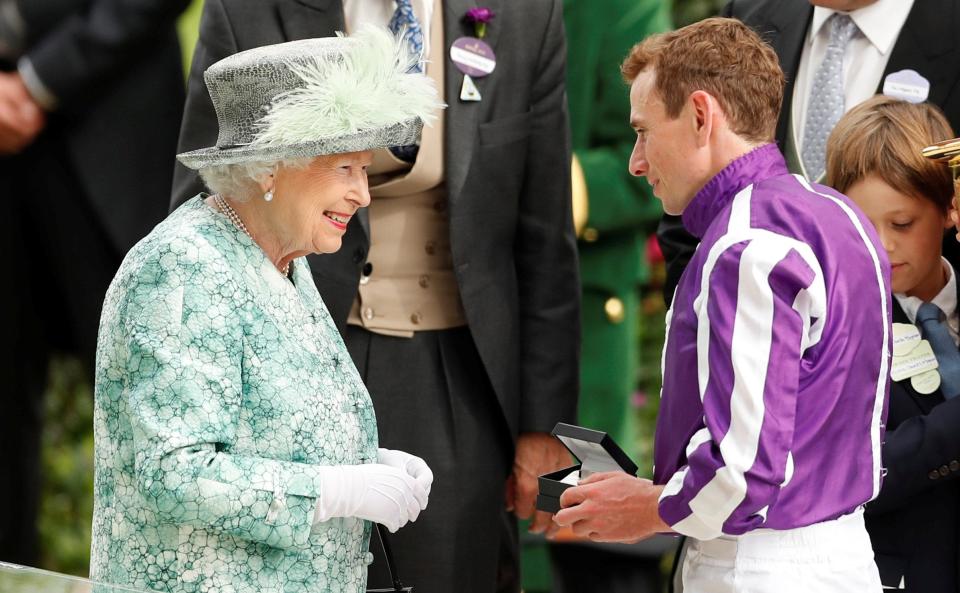  Jockey Ryan Moore receives his prize from the Queen