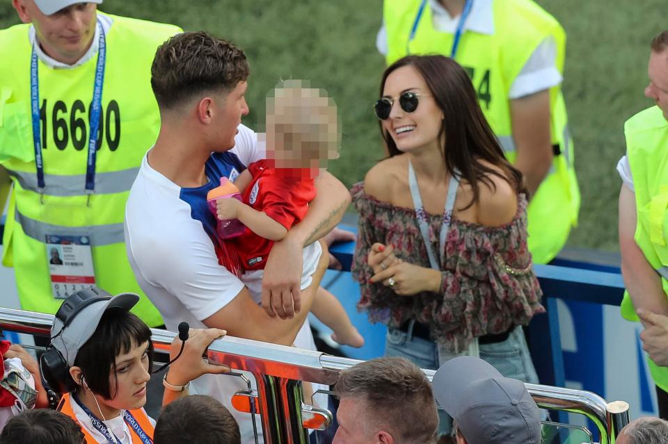  John Stones carries his child after the full-time whistle