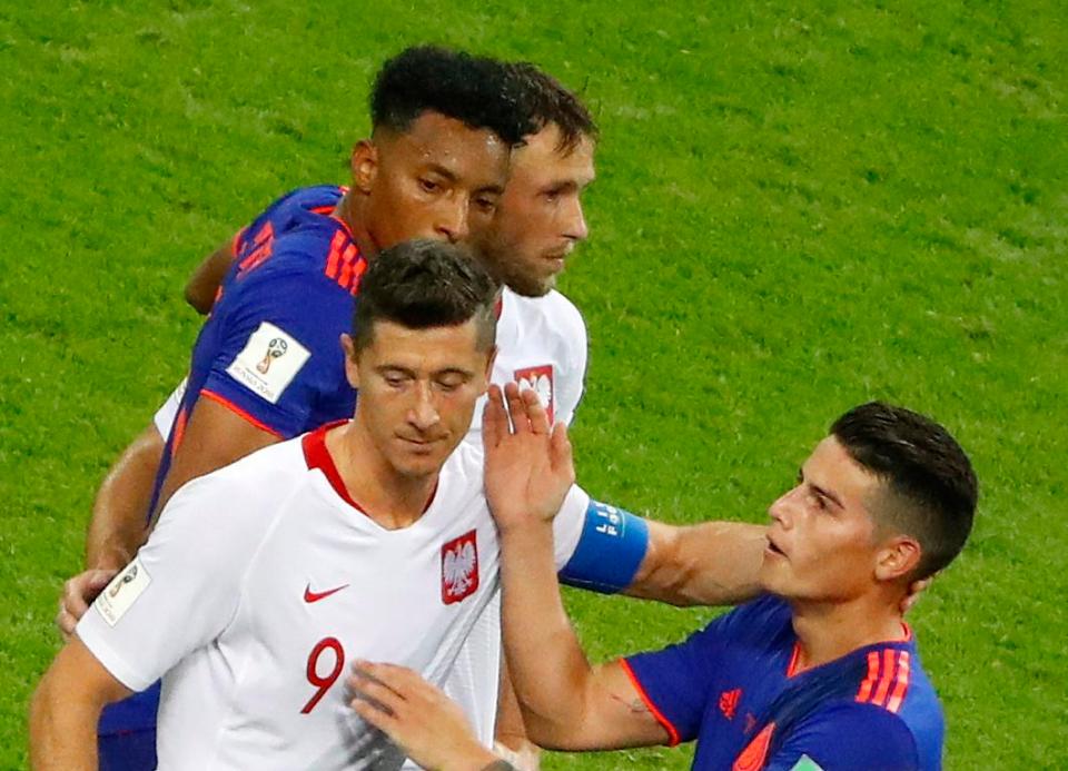  Rodriguez consoles Lewandowski after Colombia knocked Poland out of the World Cup