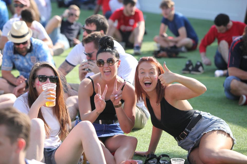 Three women enjoy the sunshine and football in Bristol