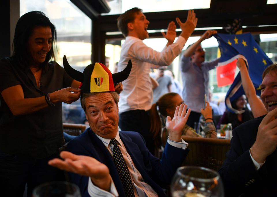 Nigel Farage shrugs after sporting a Belgian hat