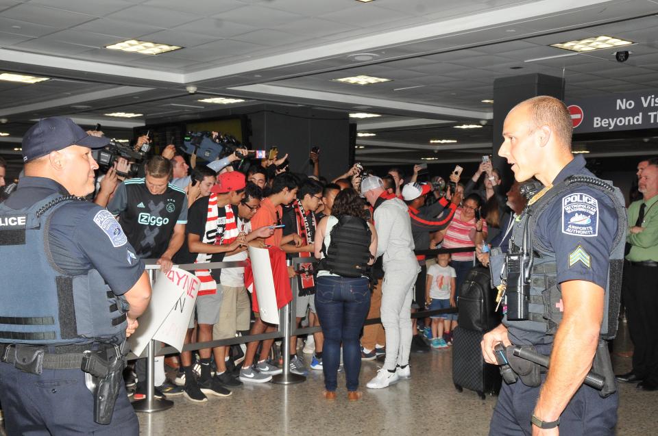  Wayne Rooney stops to sign autographs as he is flanked by a heavy police presence