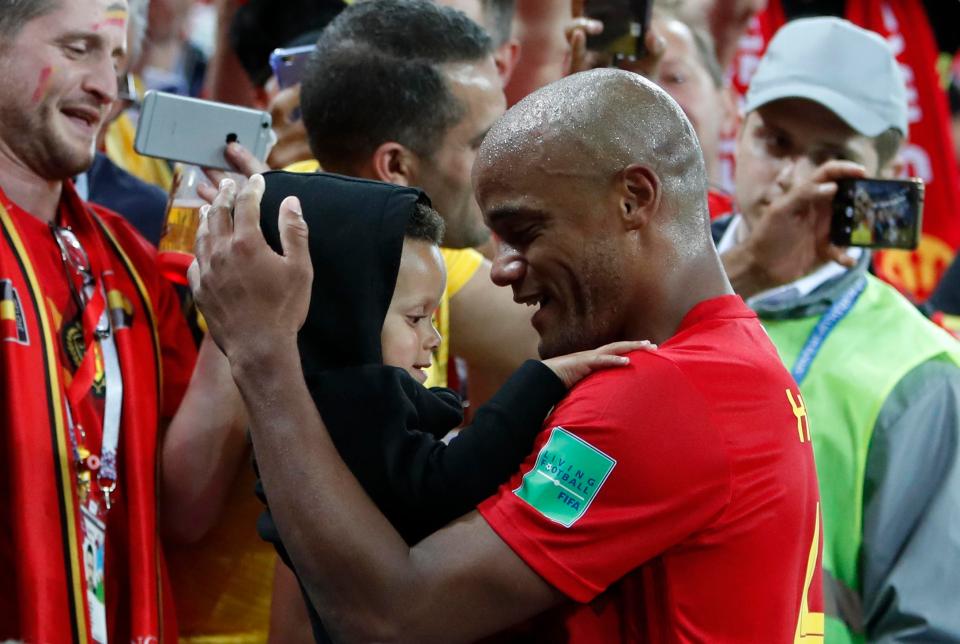 Vincent Kompany cradles his baby after the Manchester City man helped Belgium beat England 