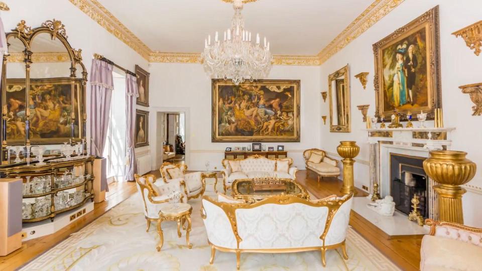  A reception room features gilt furniture and dramatic artwork on the walls