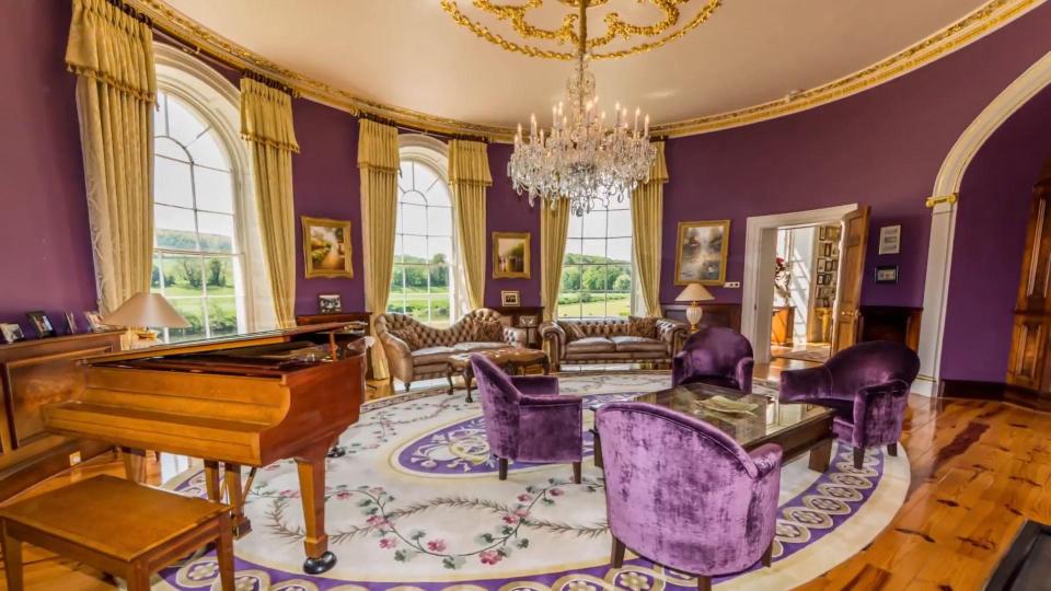  A piano sits inside a curved room that boasts spectacular views of the countryside