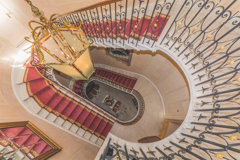  A grand, sweeping staircase descends a number of floors