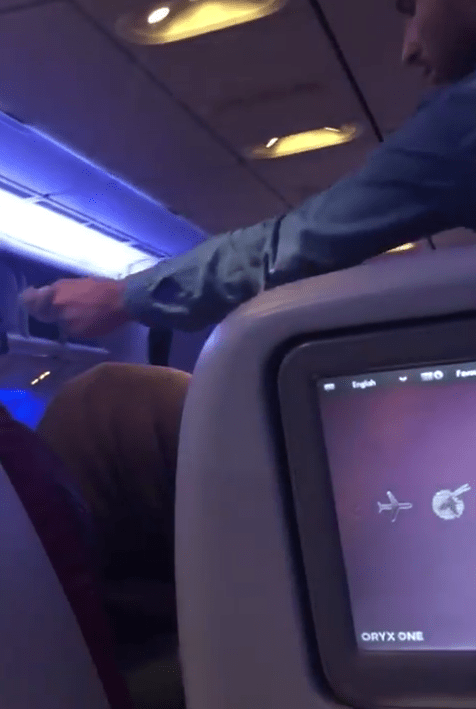  A man was filmed leaning over to give the begging man some money on the Iran-bound flight