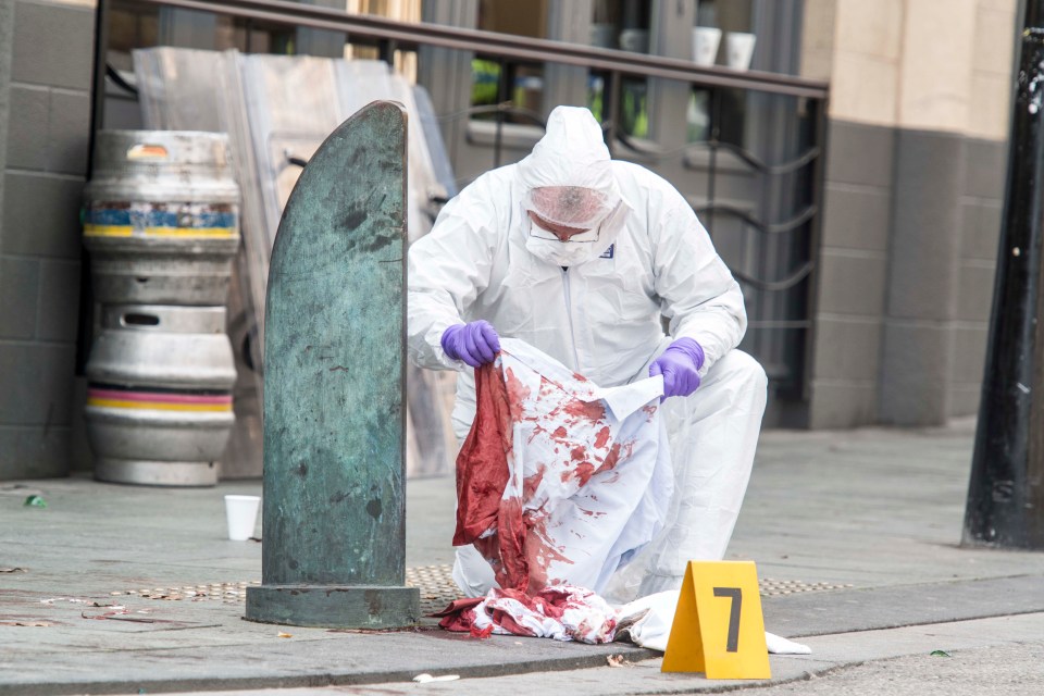 A police CSI officer inspects blood-stained clothes in Sheffield, following multiple stabbings