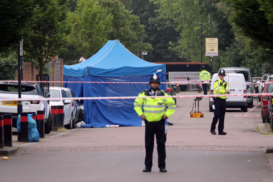  Police stand guard at the scene where shots rang out in Brent