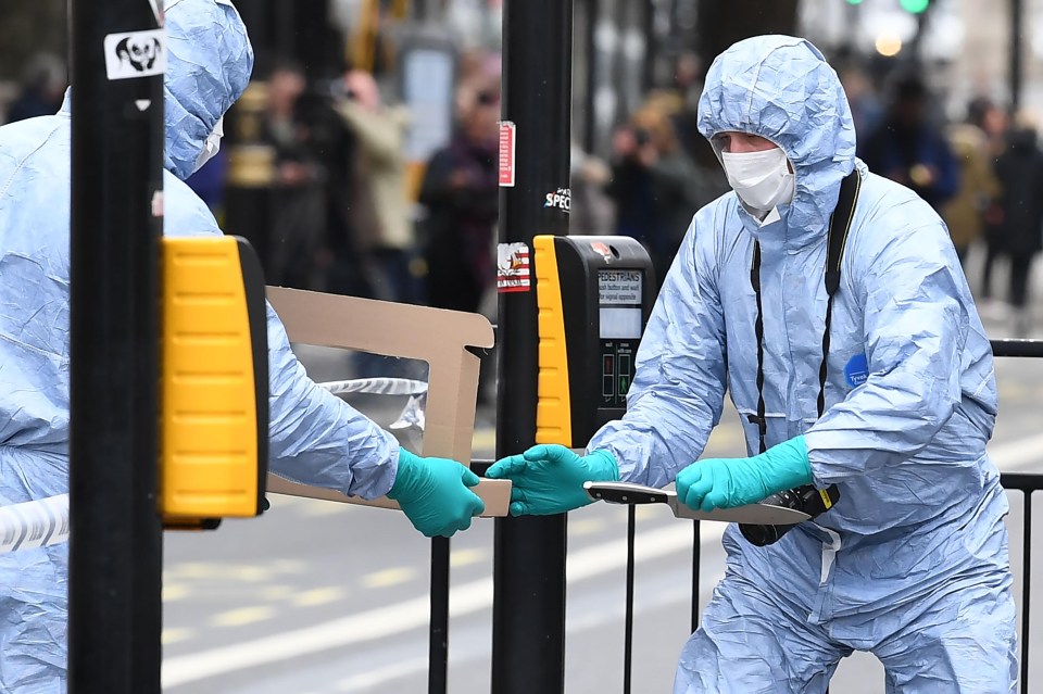 A police forensics officer passes a knife to a colleague near the Houses of Parliament