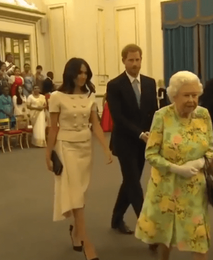  Prince Harry appeared to rebuff his wife's attempts and moved his hands away to clasp them in front of him