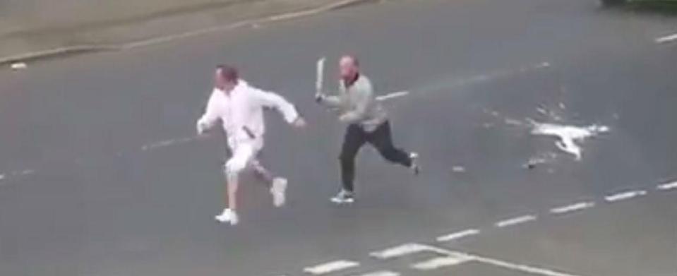  The man dressed in white turns to run away as the knife-brandishing thug gives chase