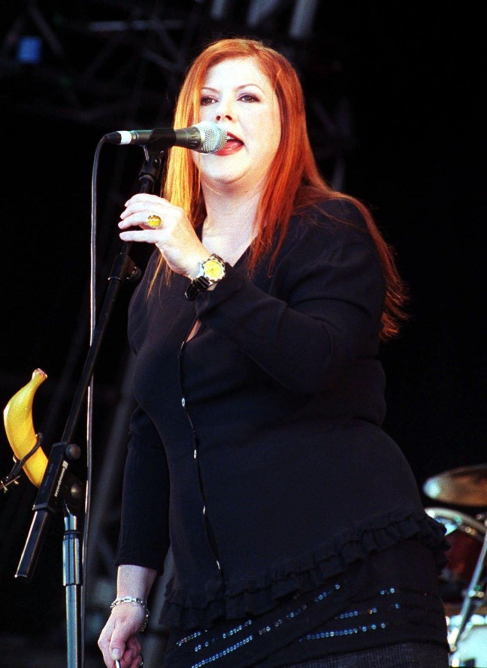 a woman singing into a microphone with a banana in the background