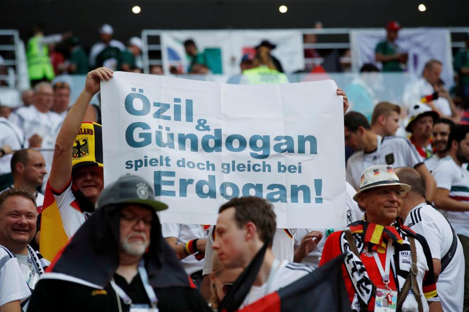  Some Germans were not happy with the duo posing for the photos - the above signs reads 'Ozil and Gundogan go and play for Erdogan!'