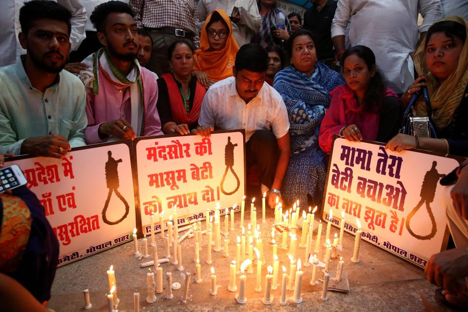  Congress party workers hold posters and light candles during a candle light vigil to protest against the rape of a seven-year-old girl