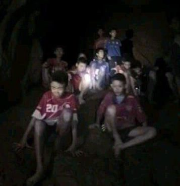  This extraordinary image shows the boys huddled up, bare foot and dressed only in their football strips, as the Brit cave divers arrive to help