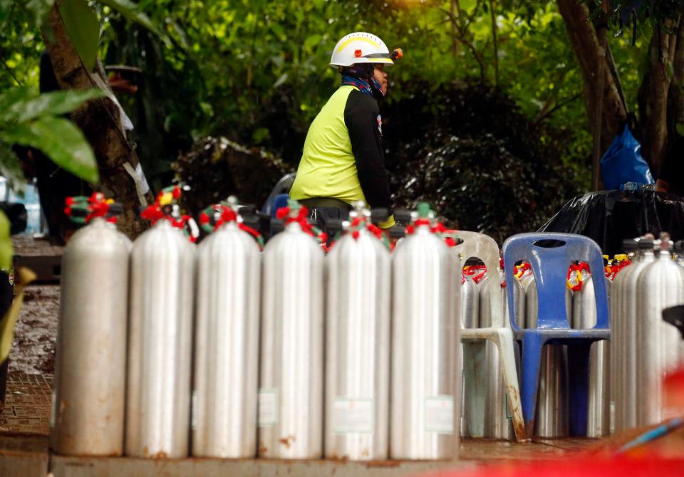  A Thai rescuer prepares oxygen tanks for diving after the 12 boys and their coach were found alive