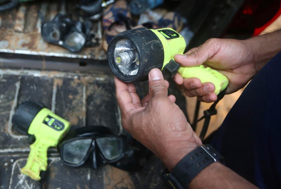  Underwater torches are prepared for use in the cave rescue