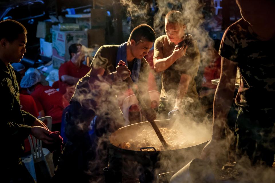  A soldier cooks dinner for rescuers at the makeshift camp at Khun Nam Nang Non Forest Park