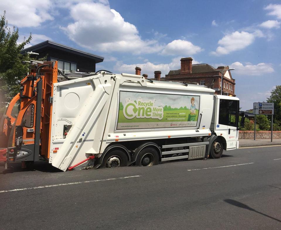  A bin lorry got stuck after it sank into melted tarmac in Berkshire yesterday during Britain's summer scorcher