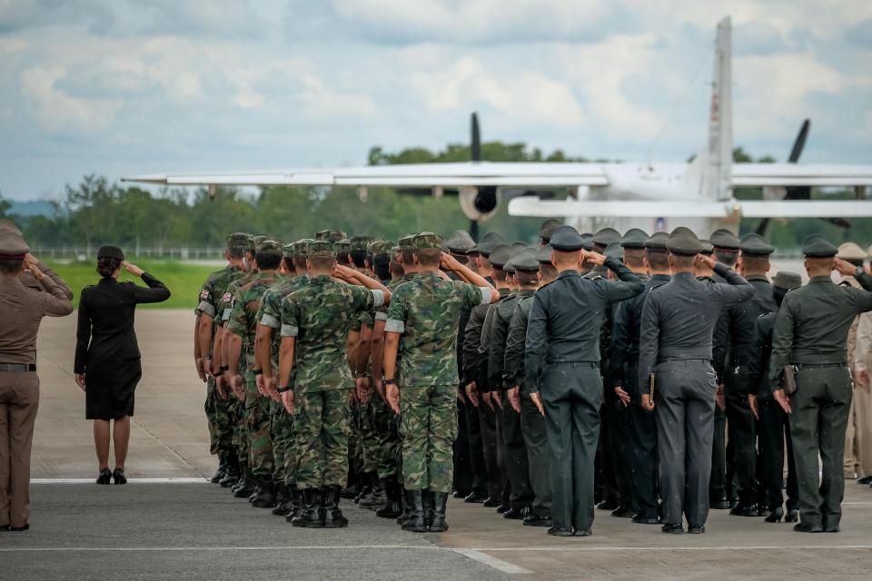  Troops stand to attention and salute as the fallen hero's body is taken away