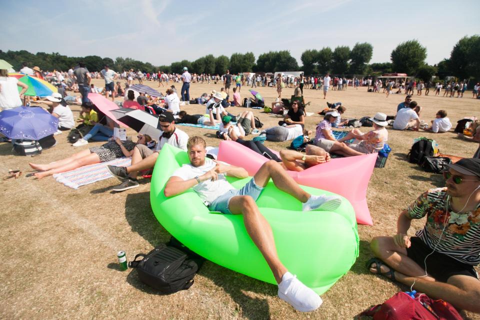  This sunbather came prepared as he lies on an inflatable chair in the queue for tennis tickets