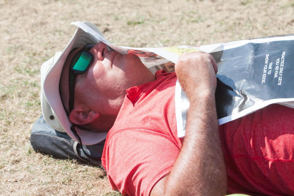  A sweltered sports fan takes a rest as he queues up for Wimbledon tickets