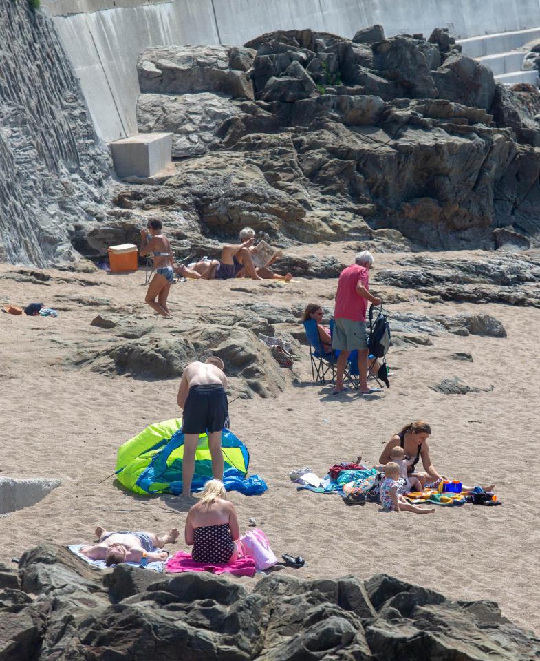  Beach-goers flocked to the sands at Porthleven in Cornwall, as forecasters predict record-breaking temperatures today