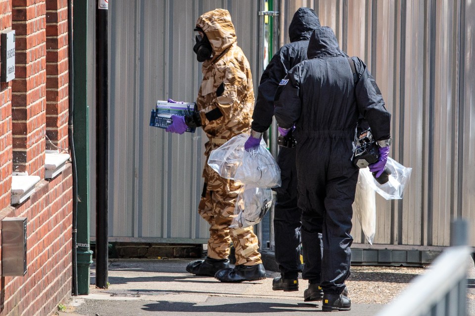 Emergency workers in protective suits search around John Baker House after the couple fell ill