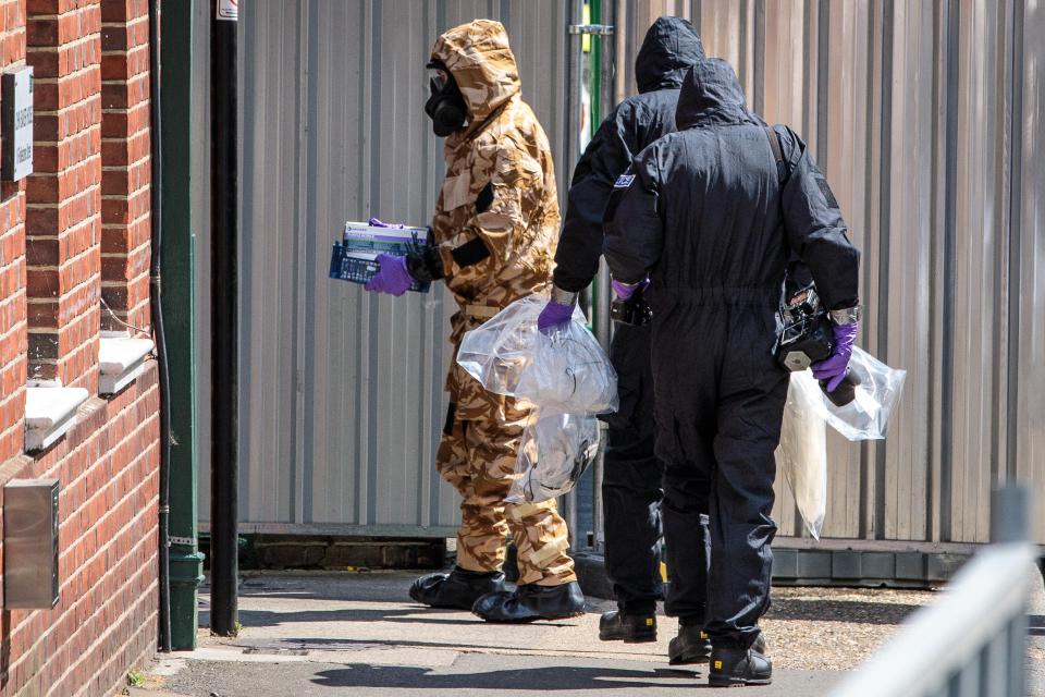  Emergency workers in protective suits search around John Baker House after the couple fell ill