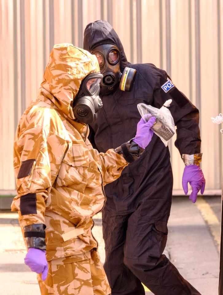  Police and army chemical weapons experts in hazmat suits examine items from the hostel in Salisbury at the centre of the latest poisoning incident