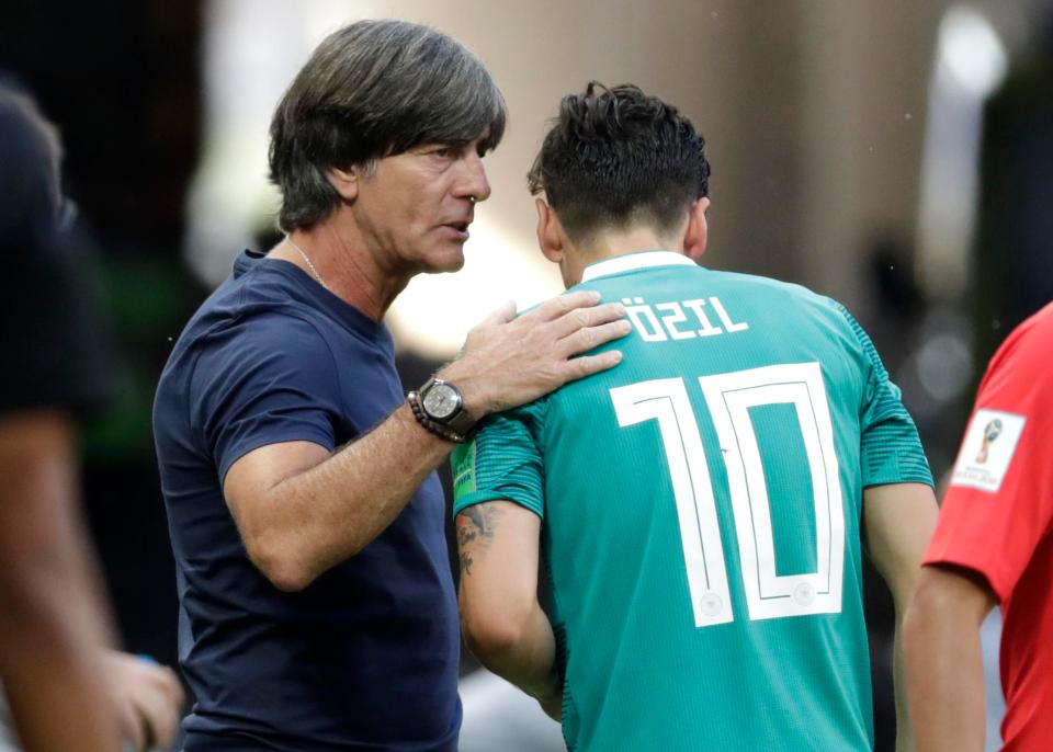  Germany boss Joachim Low consoles Mesut Ozil after the shock World Cup exit